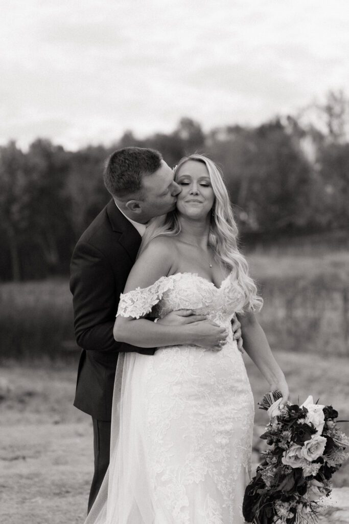 groom kissing bride on the cheek on their wedding day