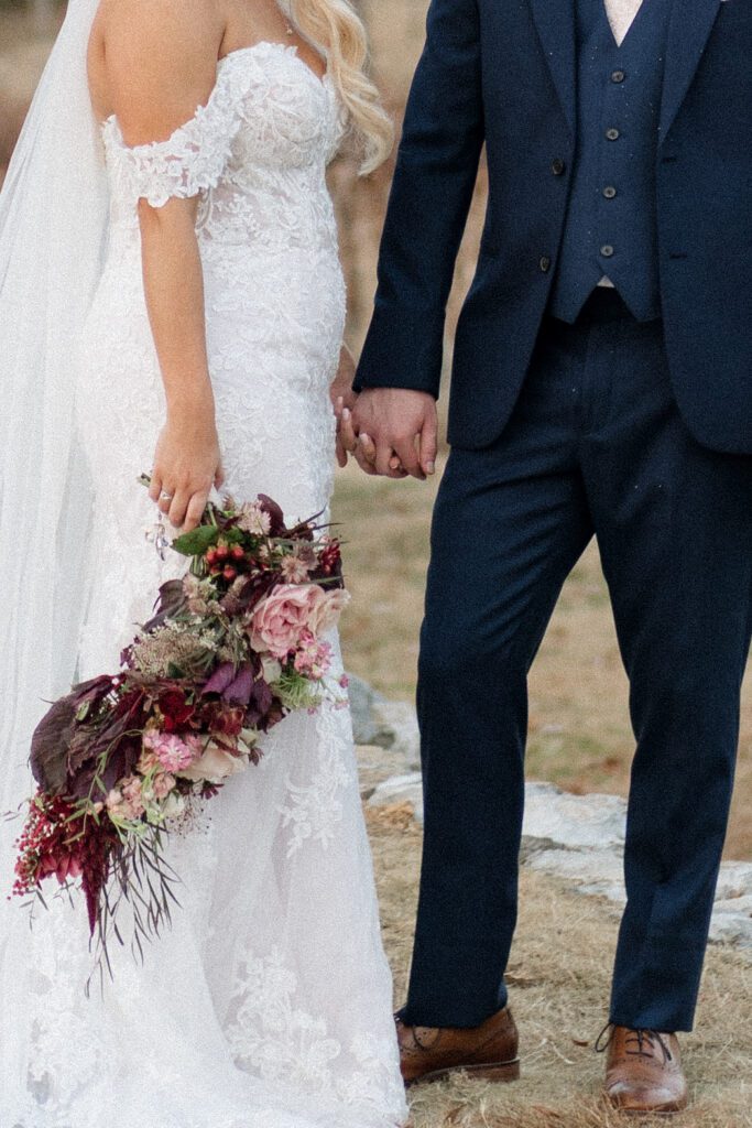 close up photo of bride and groom holding hands on their wedding day