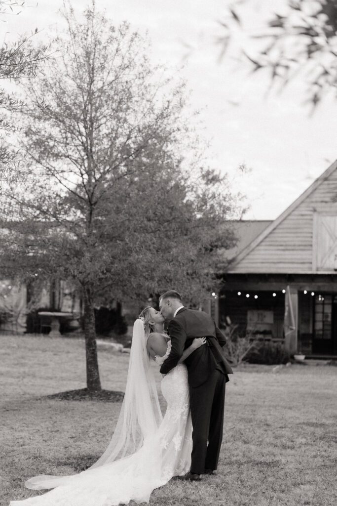 couple sharing a candid kiss moment outside their wedding venue