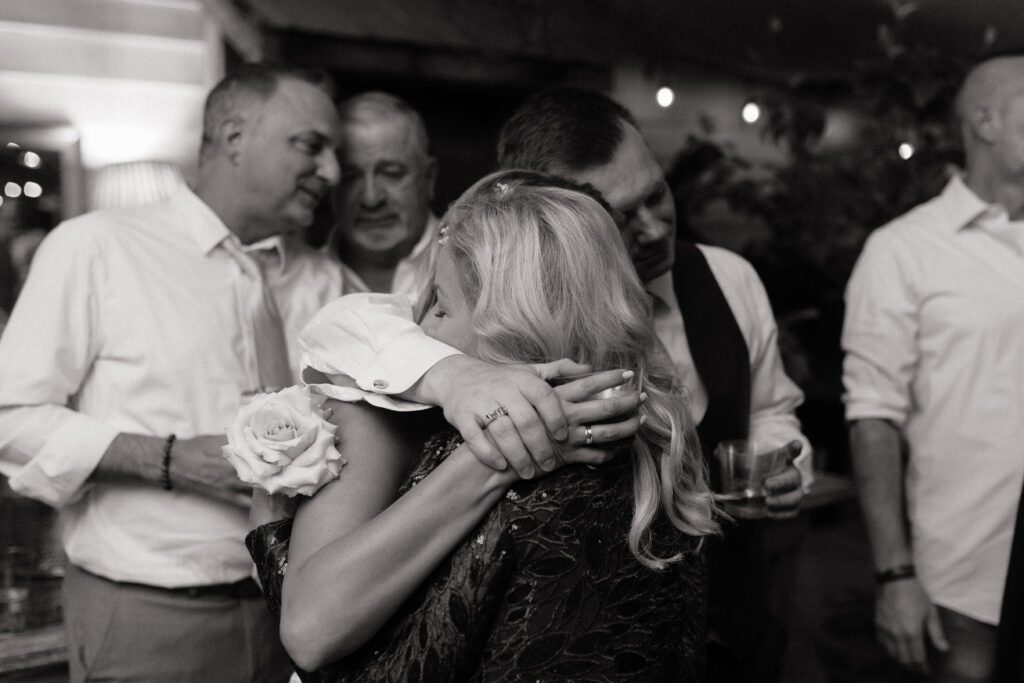 emotional moment between bride and groom and her mom