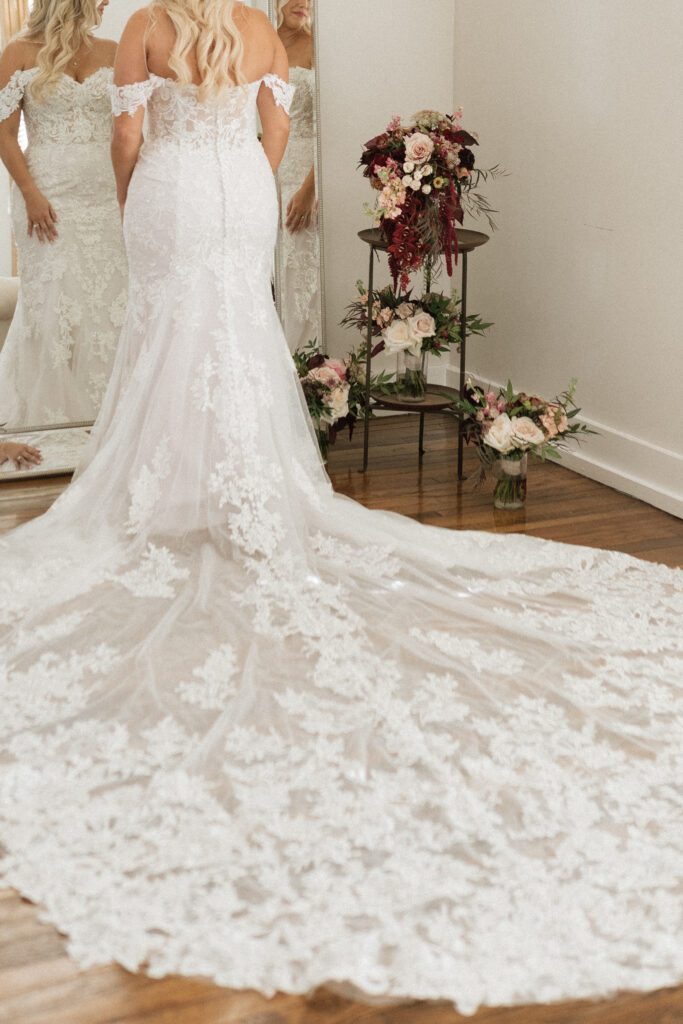 bride looking in the mirror surrounded by bouquets