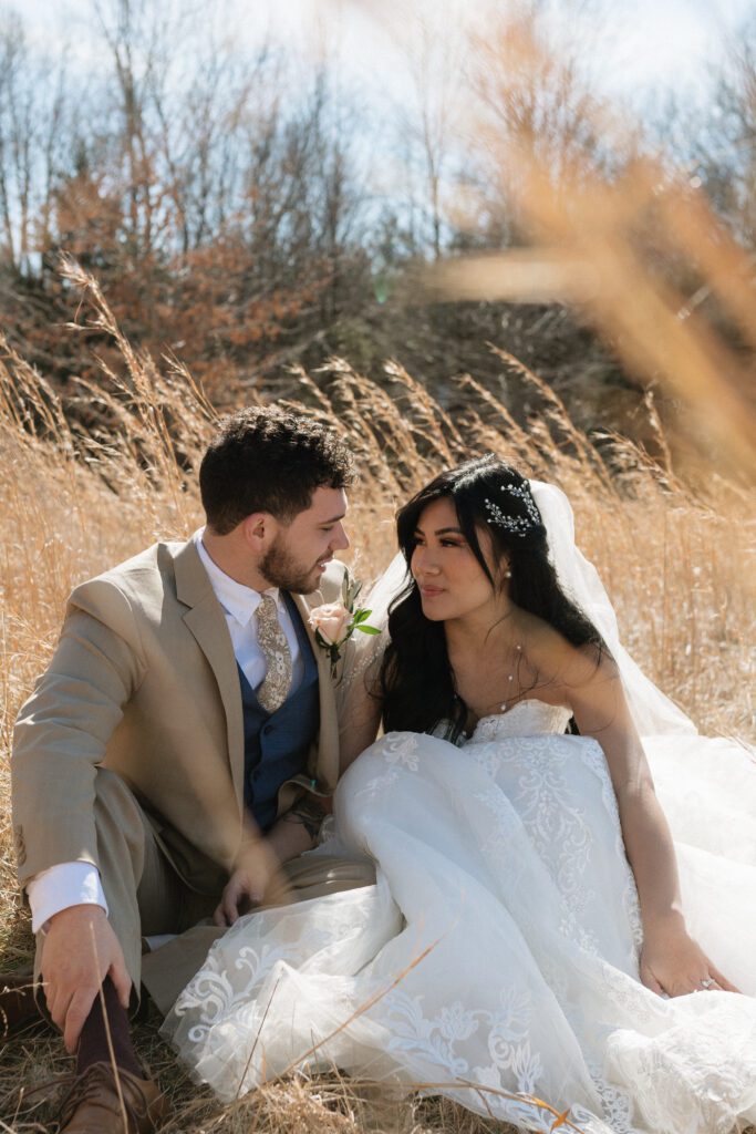 couple sitting in the tall grass at their elopement at long hunter state park in nashville