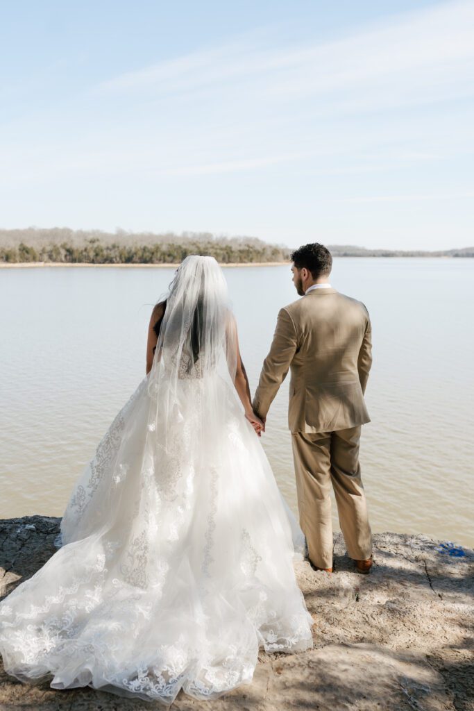 couple holding hands & overlooking the lake in nashville