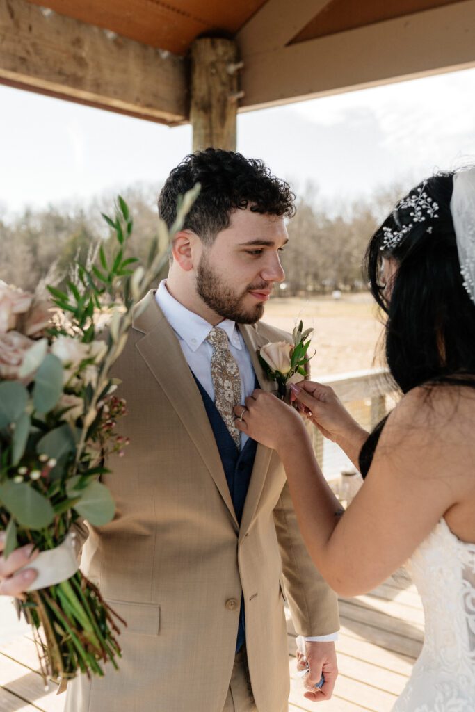 bride pinning flowers on her groom before their elopement in nashville