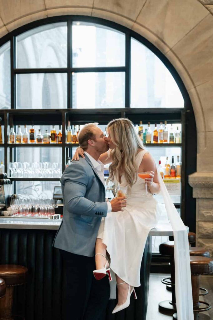 couple kissing at the bar during engagement pictures