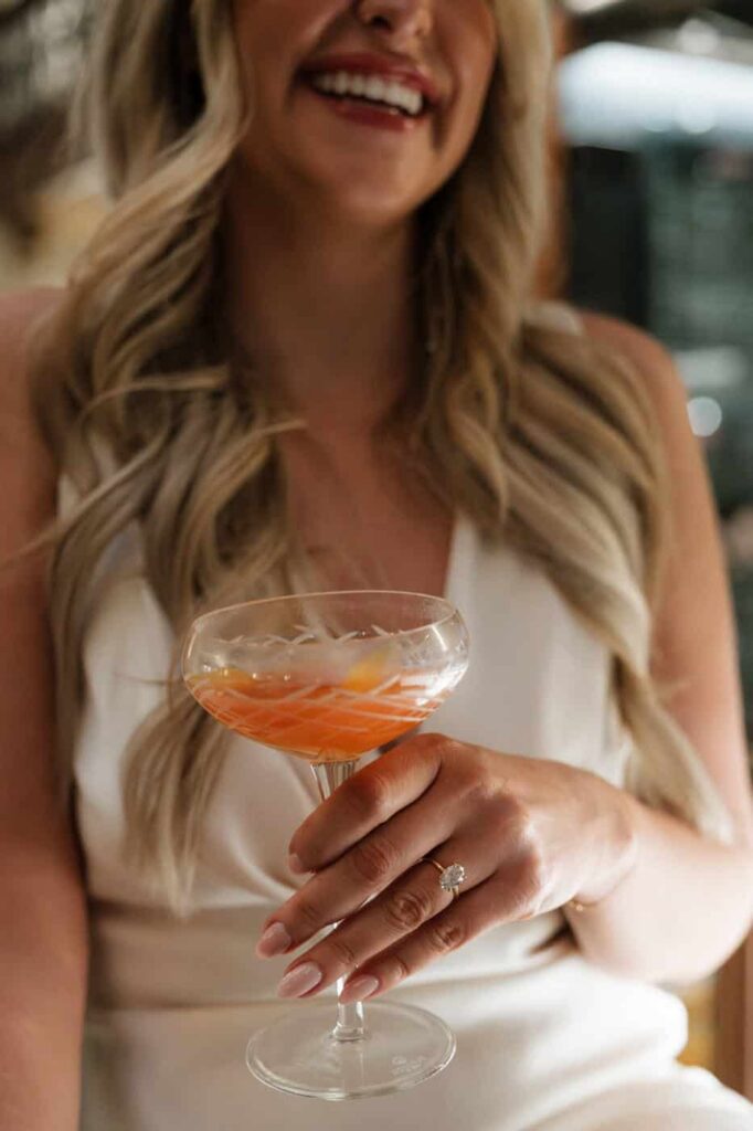 close up of girl holding a cocktail during engagement pictures