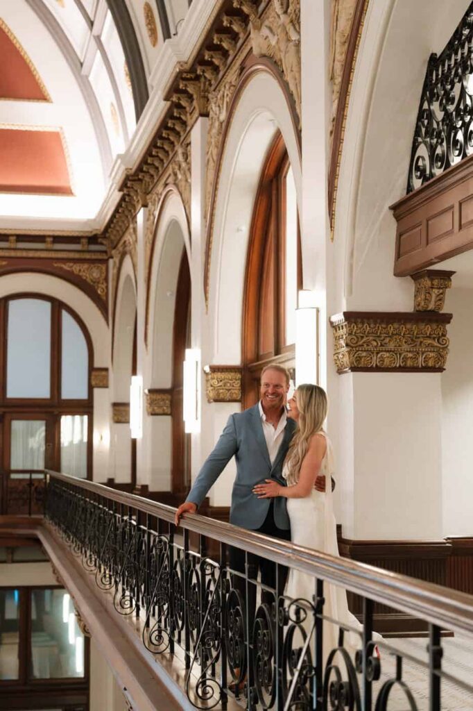 Couple embracing under arched ceilings at Union Station, Nashville engagement photographer
