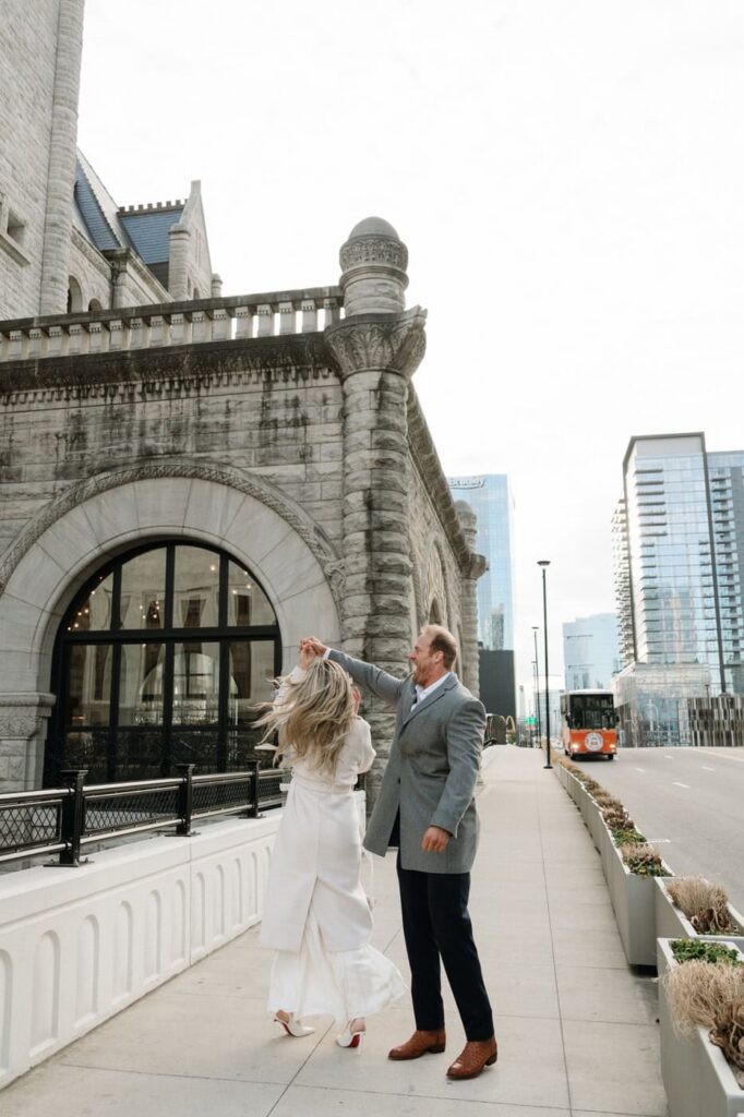 couple dancing outside union station in nashville during engagement photos