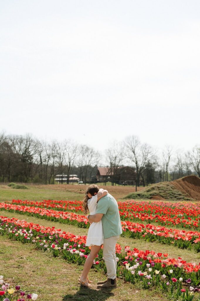 couple hugging in the middle of the tulip farm in nashville