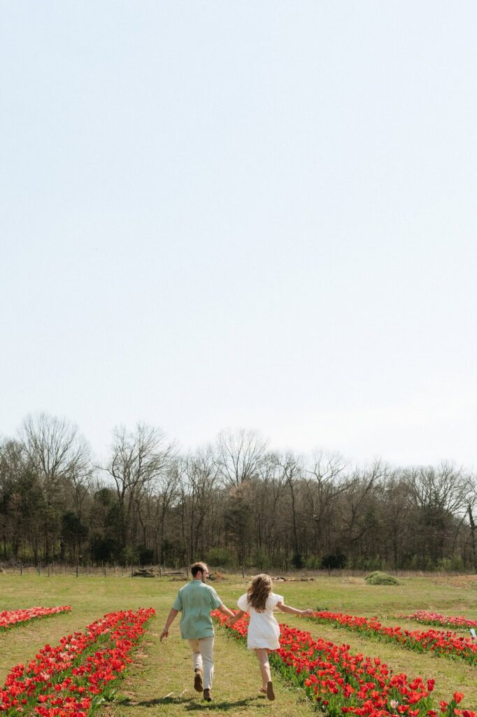 couple running through the tulip farm after their engagement in nashville