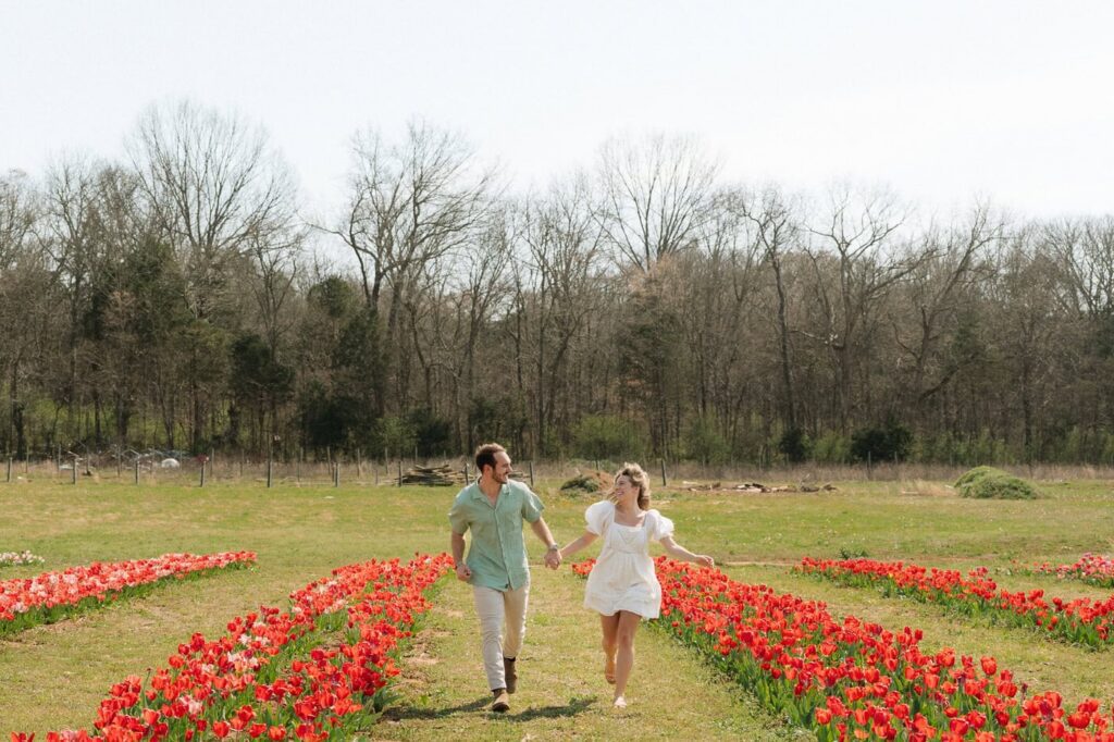couple running through tulip farm during nashville engagement session