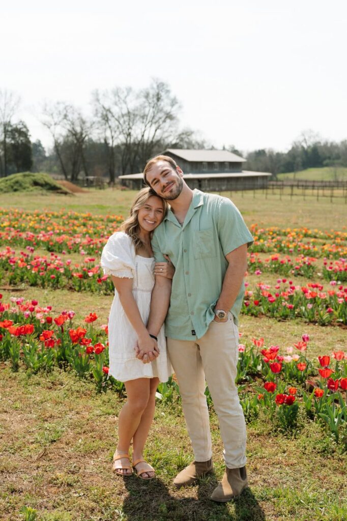 couple posing during engagement session at tulip farm engagement session