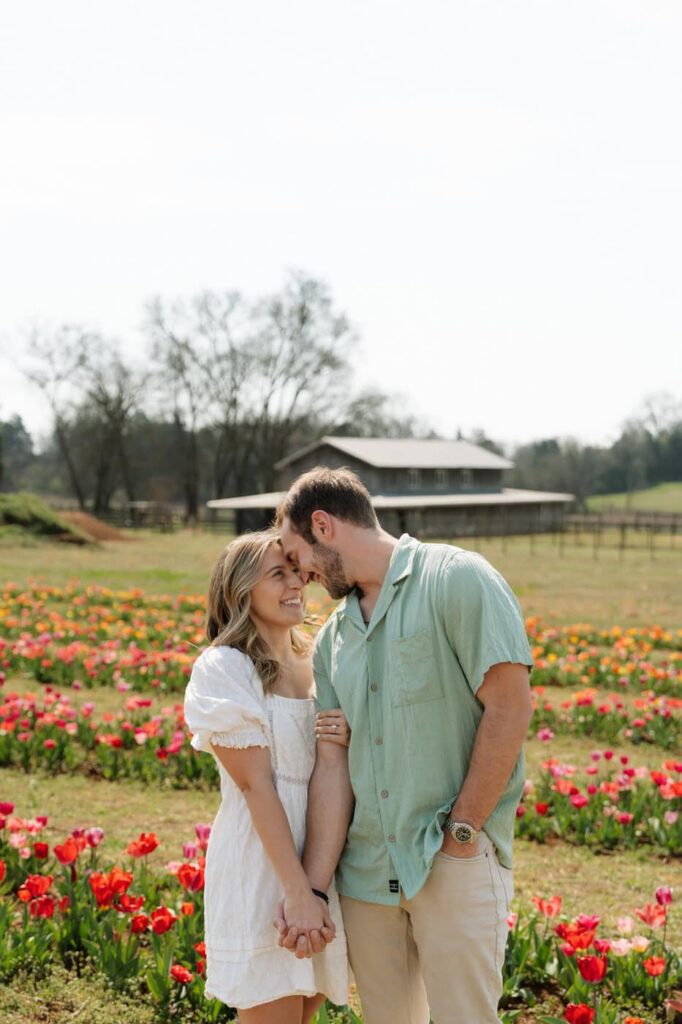 couple holding hands in front of tulips during engagement photos