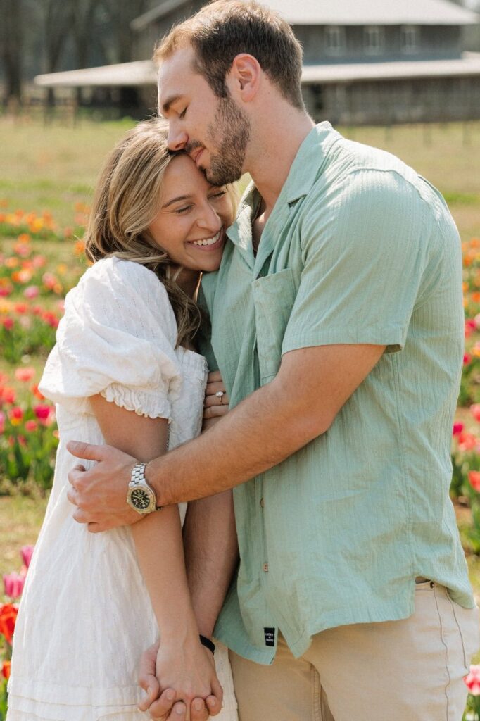 couple embracing after getting engaged at tulip farm