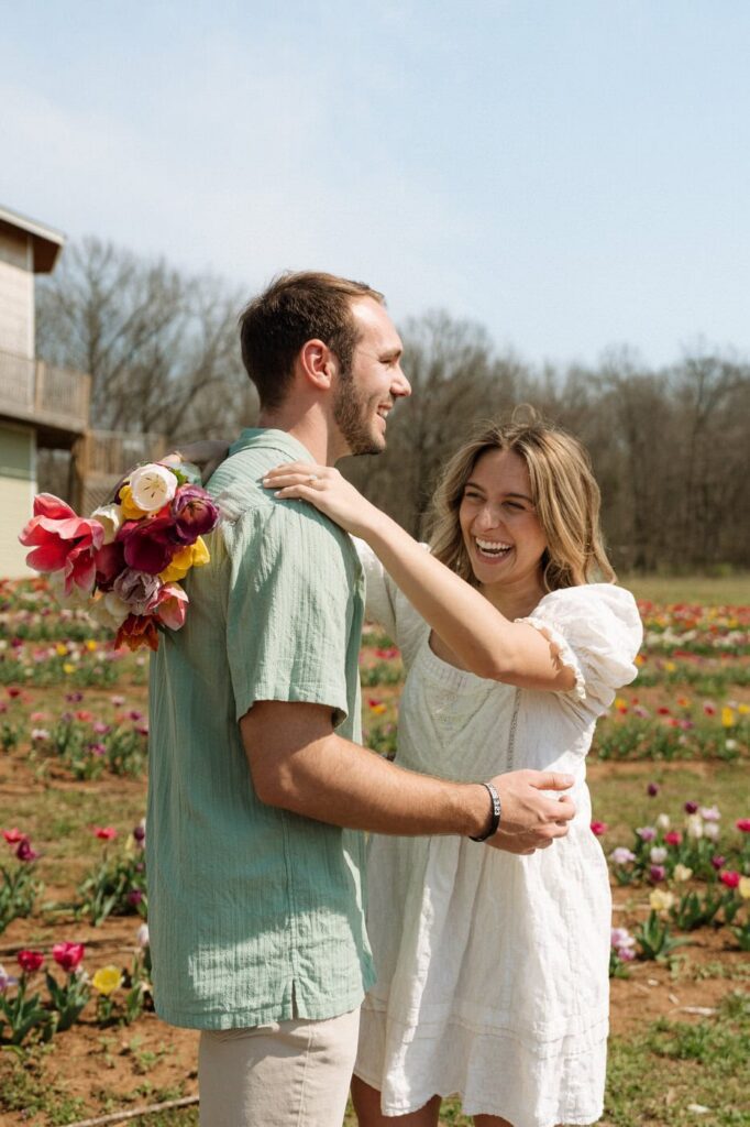 candid moment of couple laughing at tulip farm engagement session