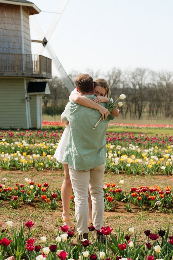 couple hugging after getting engaged at tulip farm in tennessee