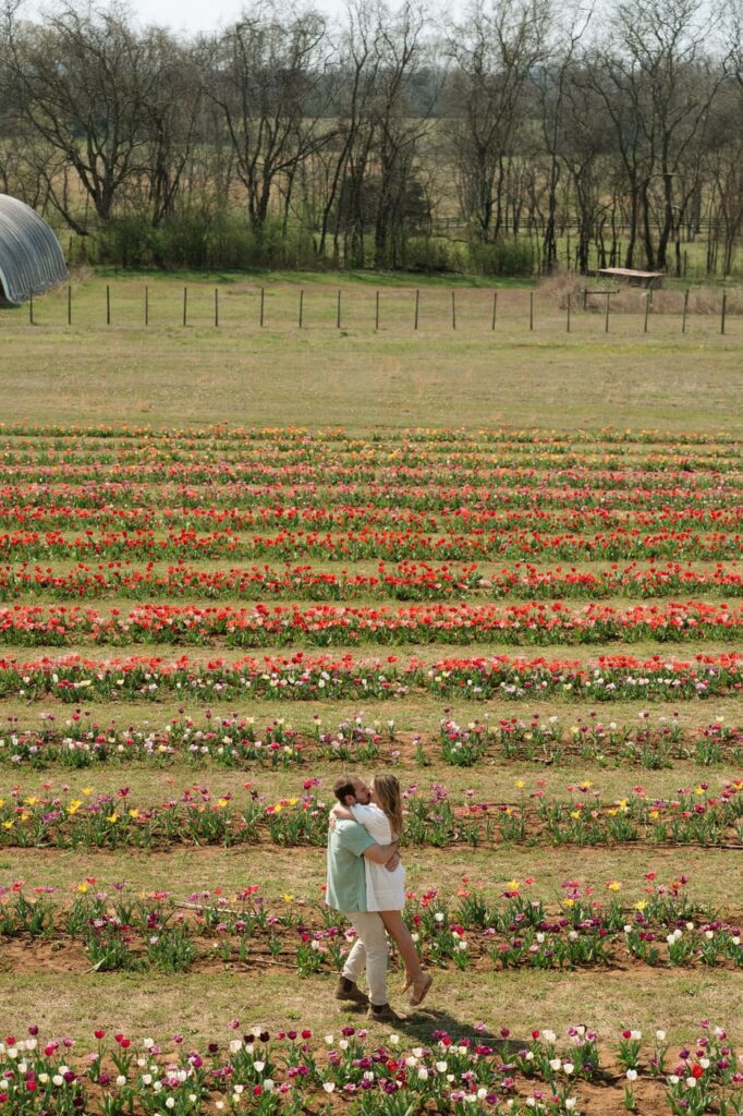 couple embracing in the middle of tulip farm engagement session