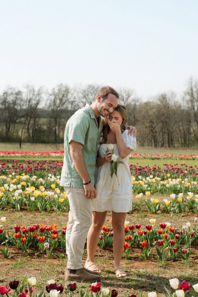 couple embracing after getting engaged at tulip farm in nashville