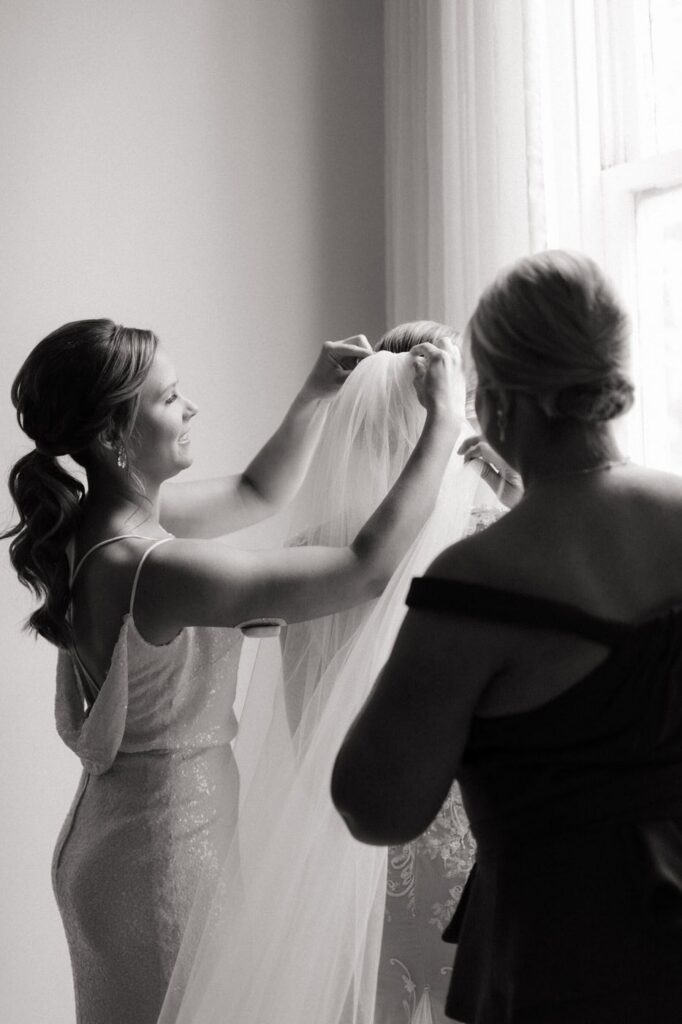 maid of honor putting the veil on the bride at nashville wedding