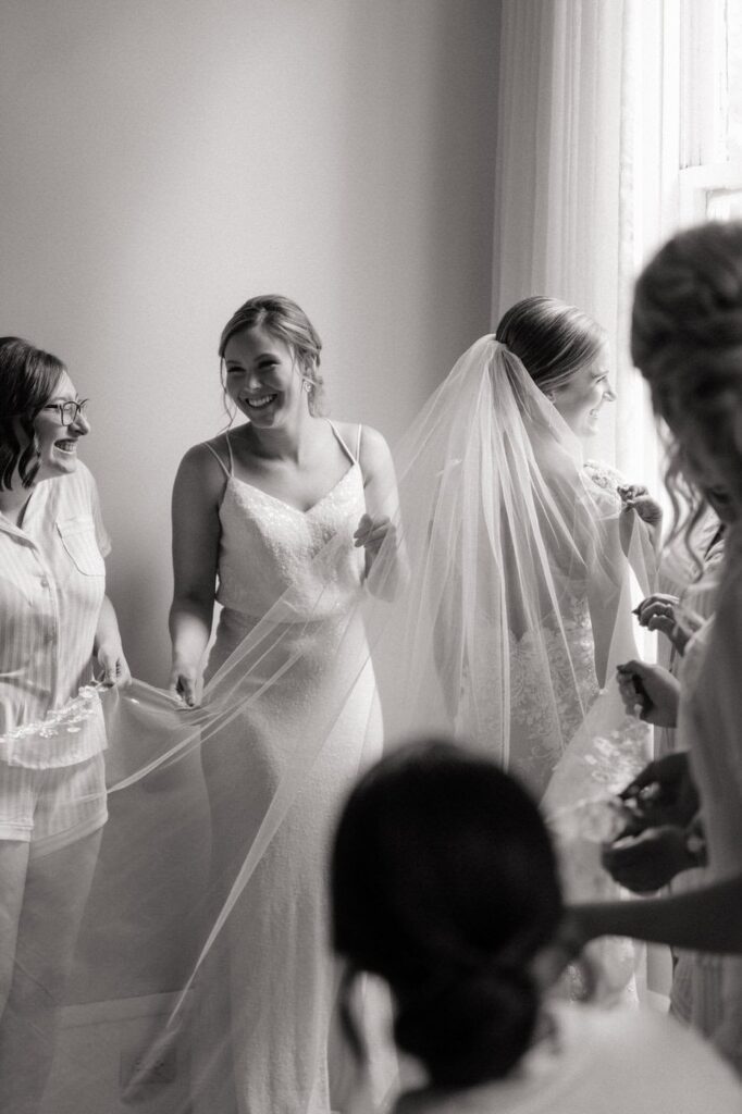 bridesmaids helping bride get ready at riverwood mansion in nashville