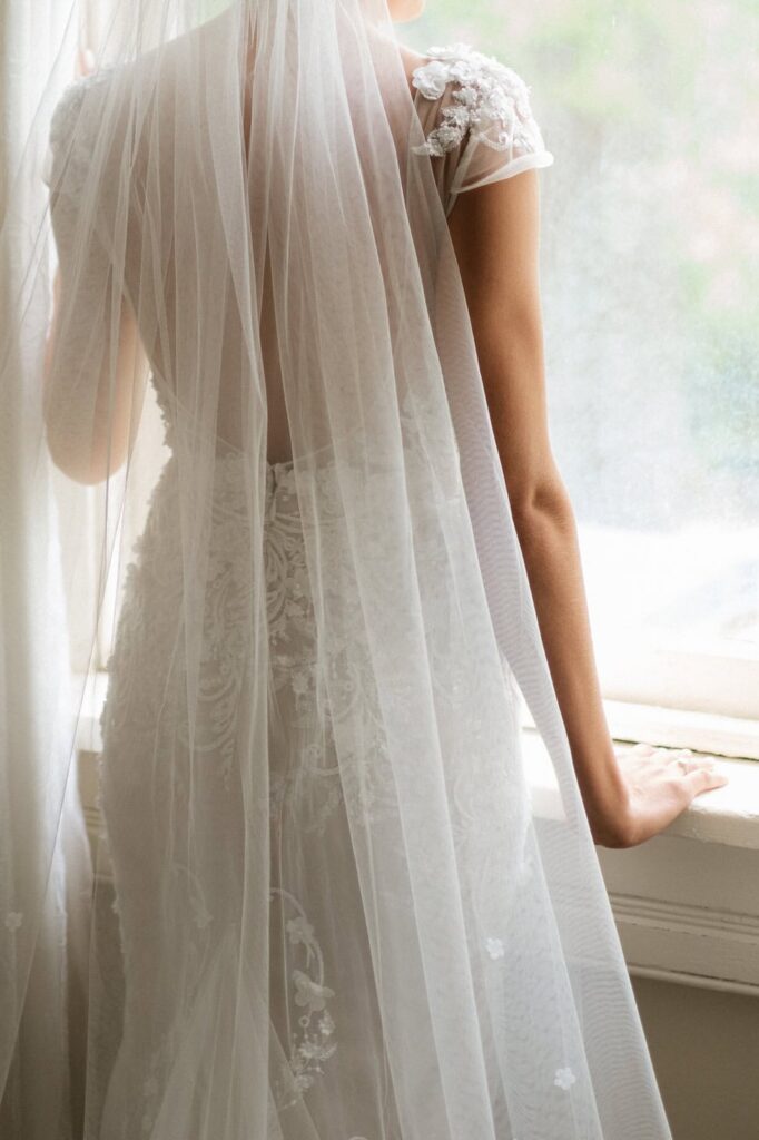 bride looking out the window on her wedding day at riverwood
