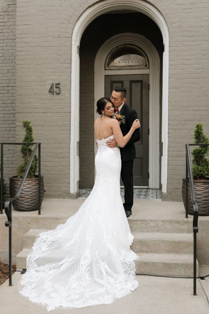 couple standing on the steps outside of the cordelle in nashville on their wedding day