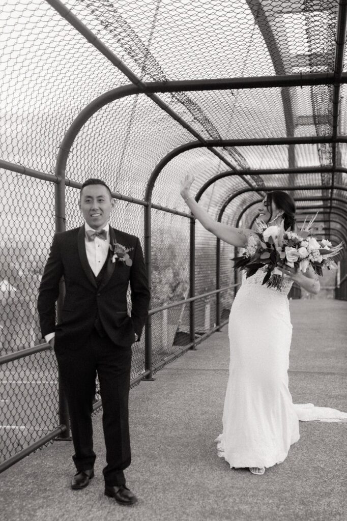 bride waving to cars driving by on her wedding day