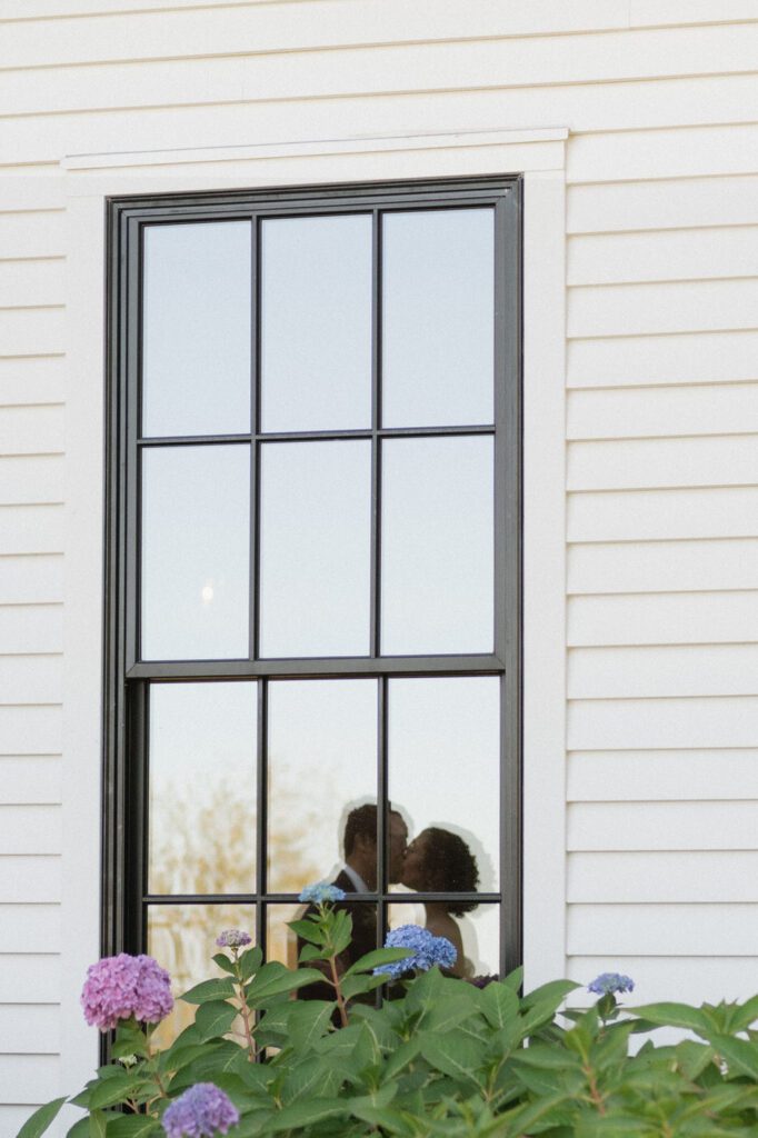 refelction of couple kissing in the window at nashville wedding venue