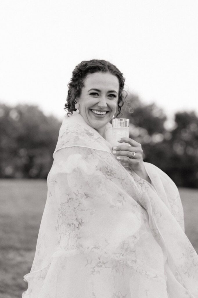 bride smiling holding a cocktail at trinity view farm wedding