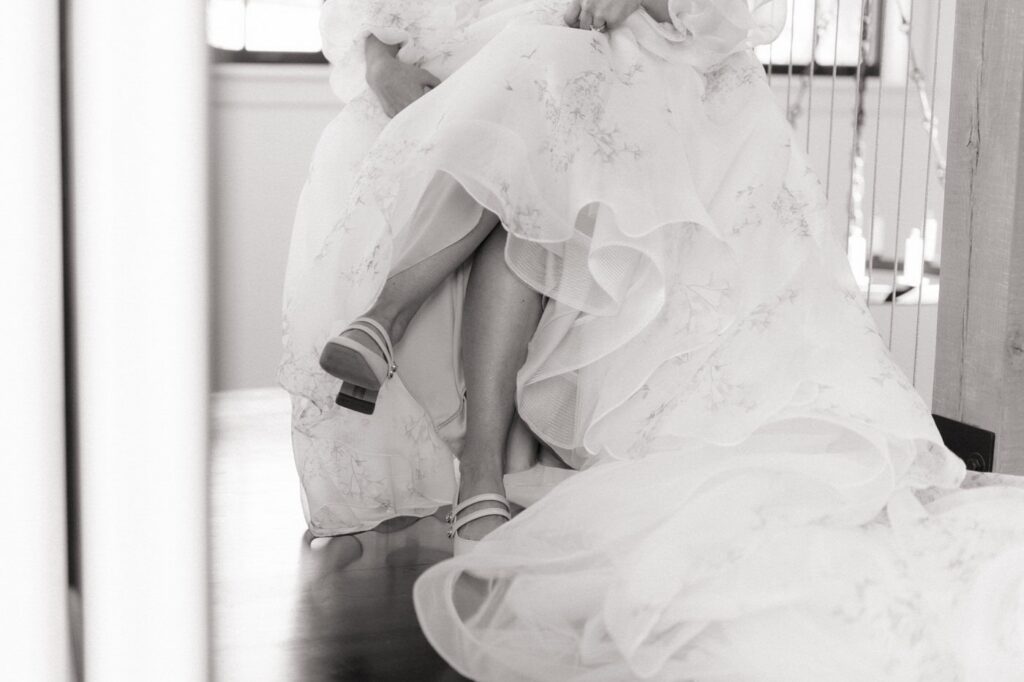 bride sitting in a chair putting on her shoes