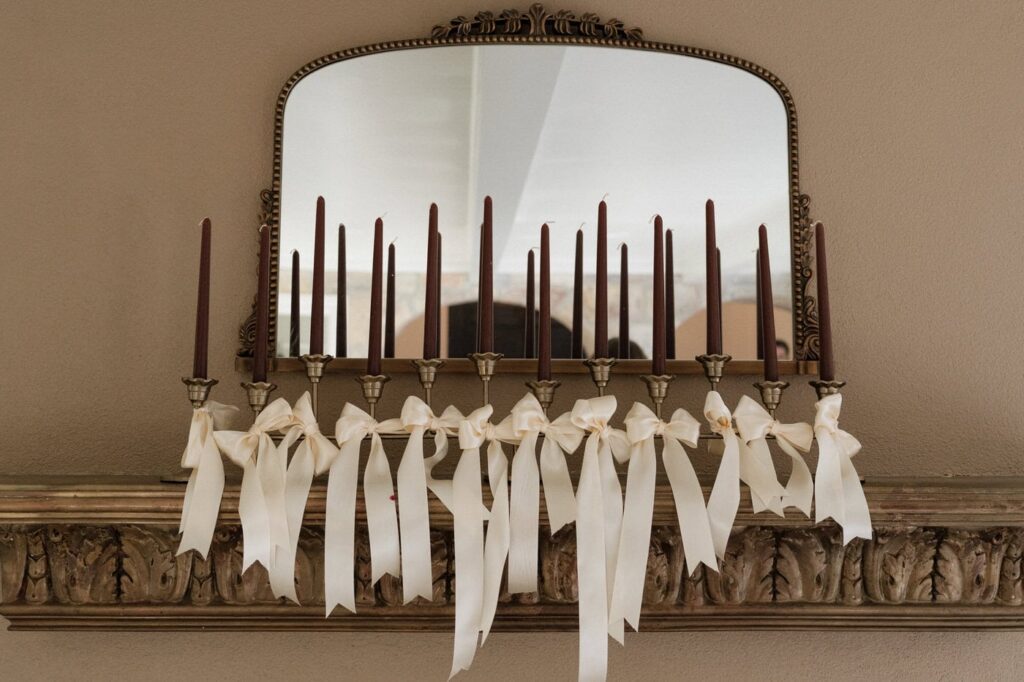 candles above the fireplace at winter wedding at the dimora