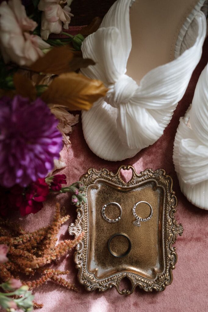 rings and shoes on a pink fabric background