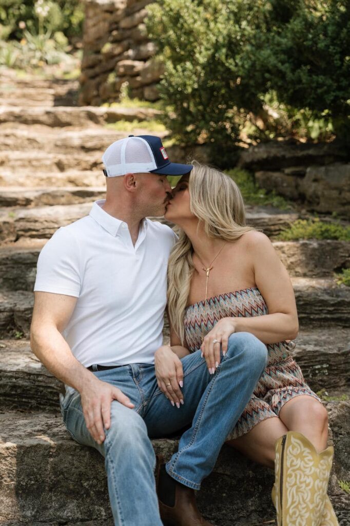 couple kissing on the stone steps at cheekwood during nashville engagement photos