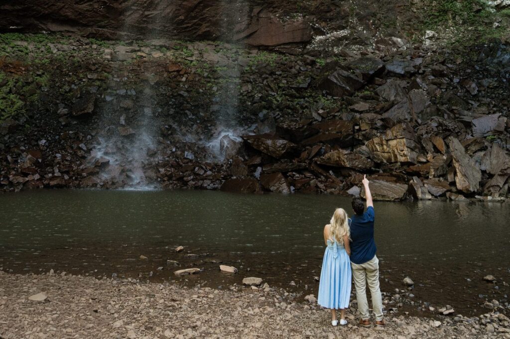 couple admiring the waterfalls during spring engagement session