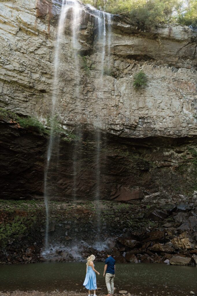 couple standing at the base of the waterfalls at tennessee state park