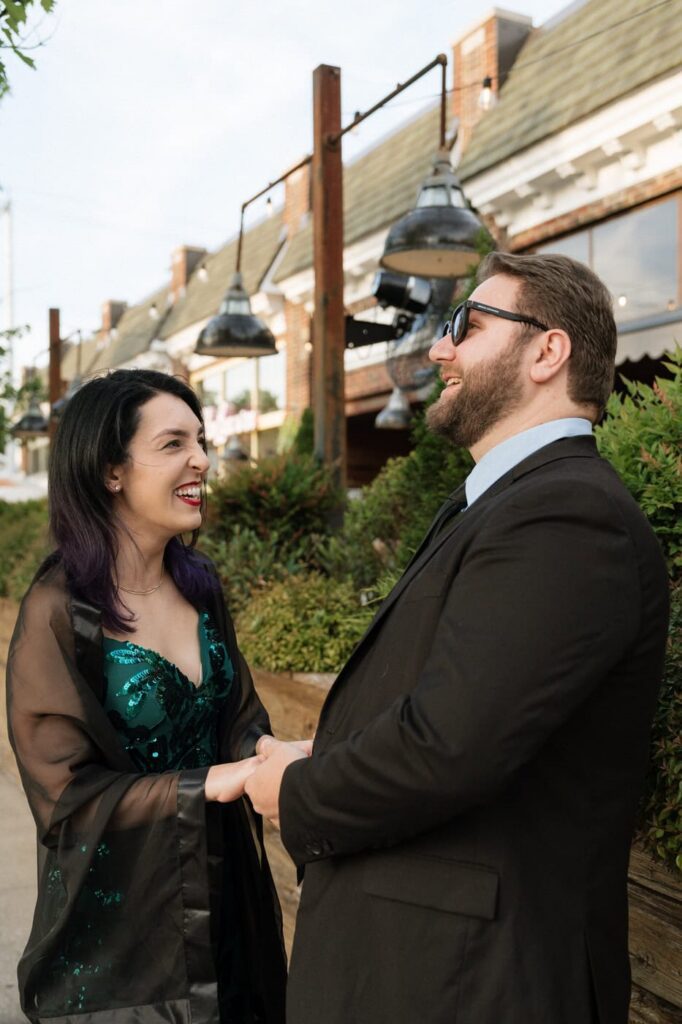 couple holding hands and laughing during midtown nashville engagement photos