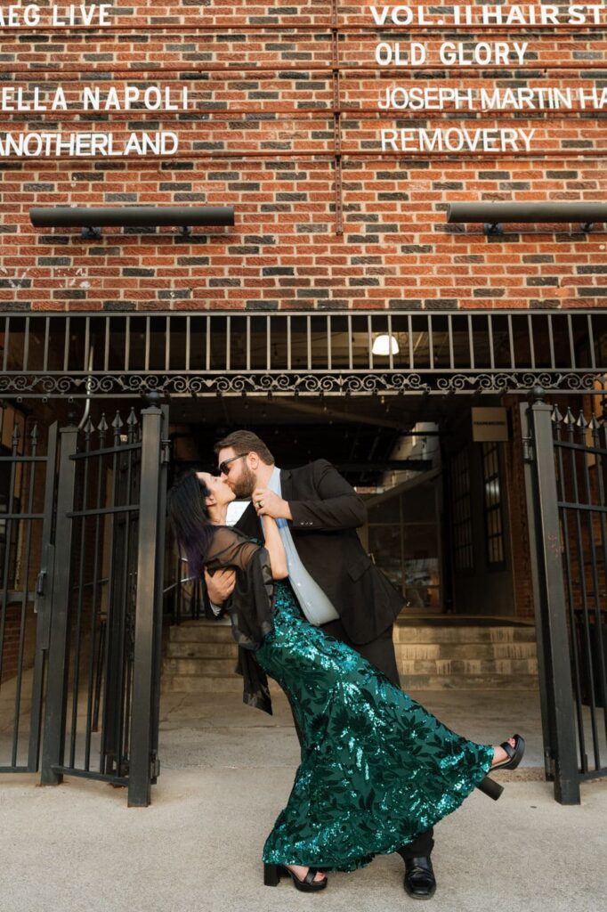 couple kissing outside of barcelona wine bar in nashville during engagement photos