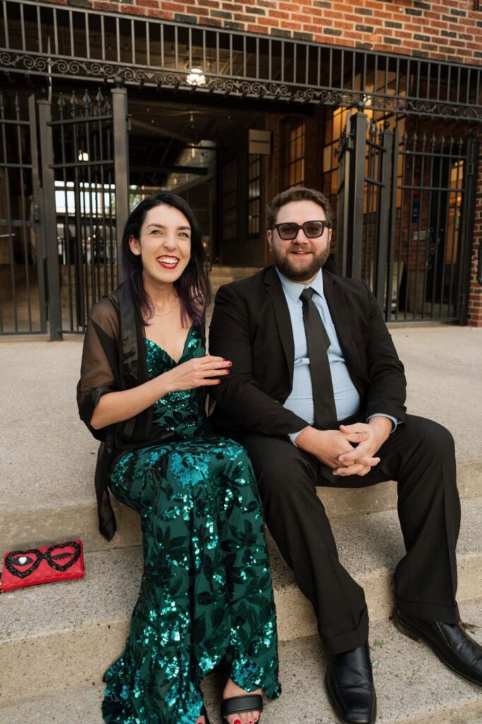 couple sitting on the stairs outside of barcelona wine bar in nashville tennessee