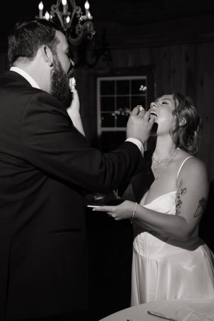 couple feeding each other wedding cake at their reception