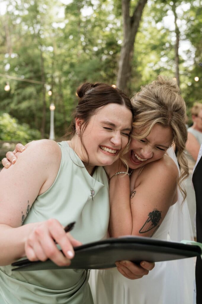 bride and maid of honor signing marriage license at nashville wedding