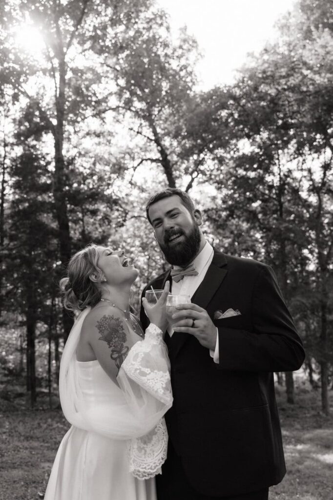 candid moment of bride and groom laughing while sipping cocktails at nashville wedding