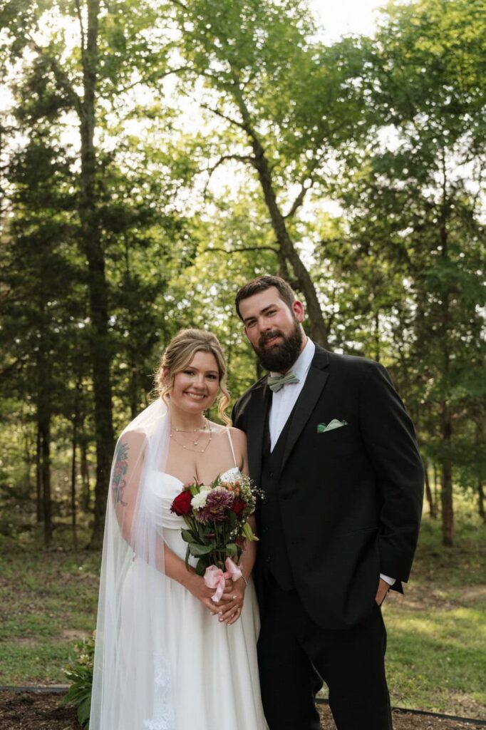 bride and groom posing and smiling for a photo on their wedding day