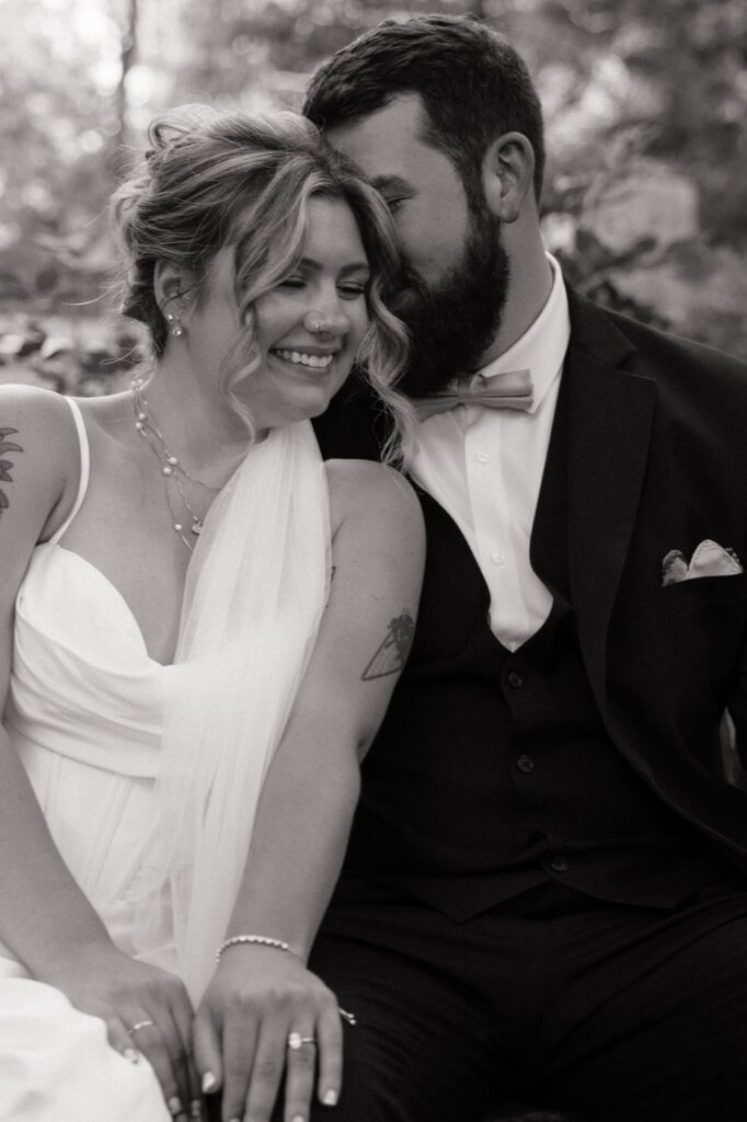 couple sharing a sweet moment sitting on a bench at nashville wedding venue