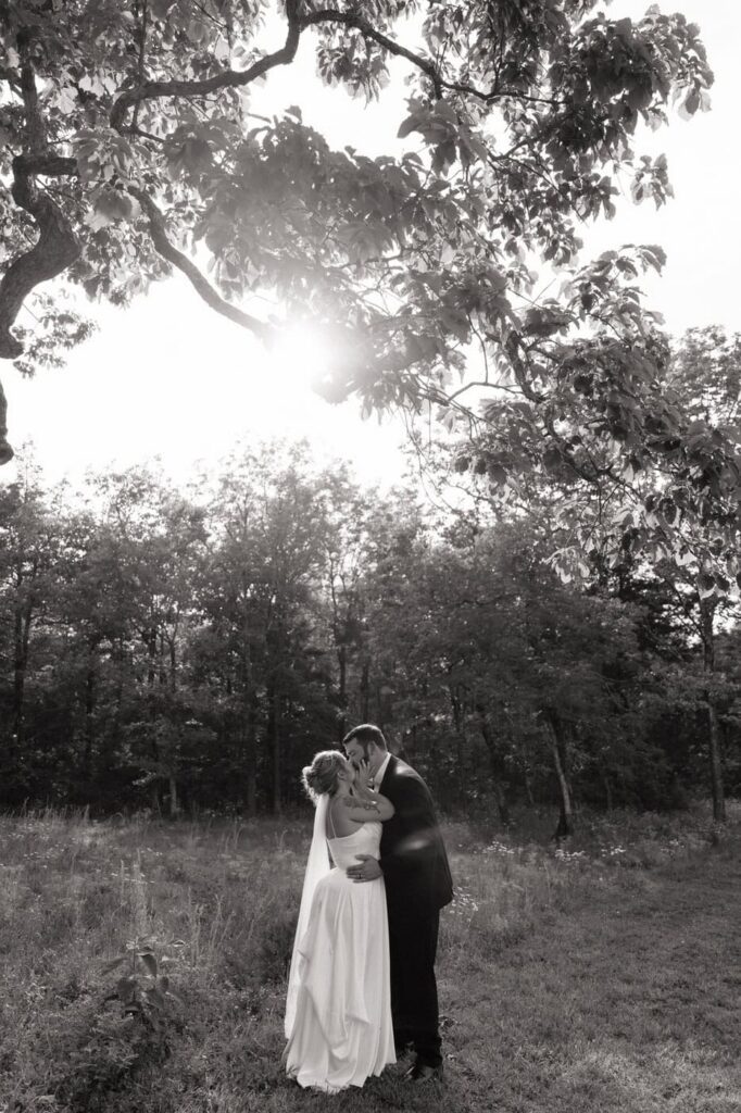 couple kissing in a field on their wedding day