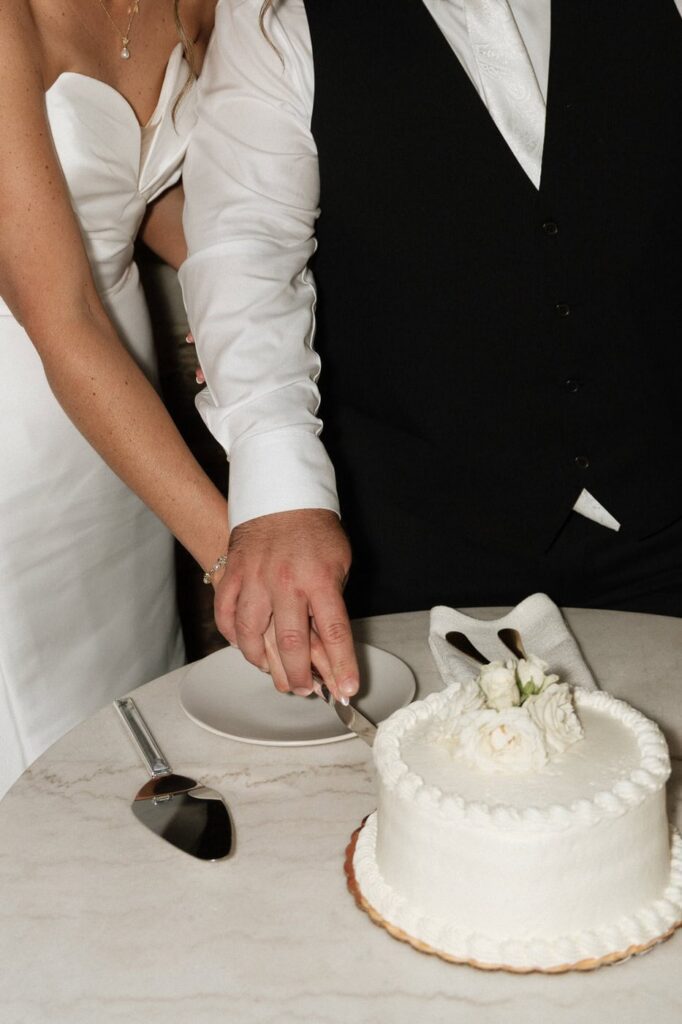 close up shot of bride and groom cutting their wedding cake in nashville wedding venue
