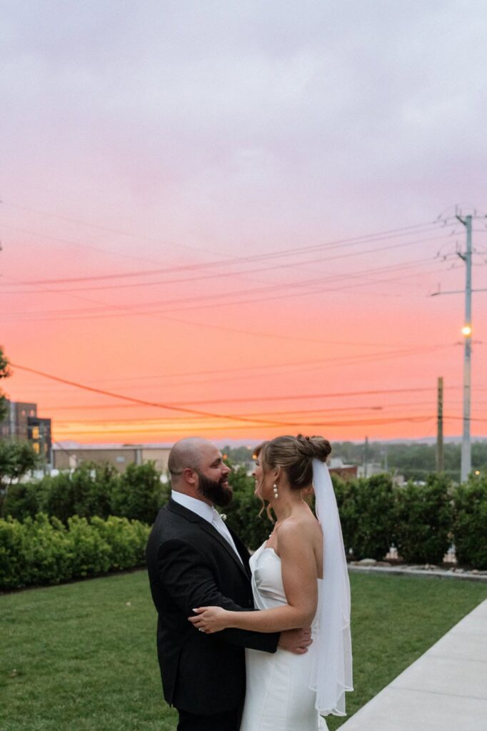 bride and groom in front of sunset sky
