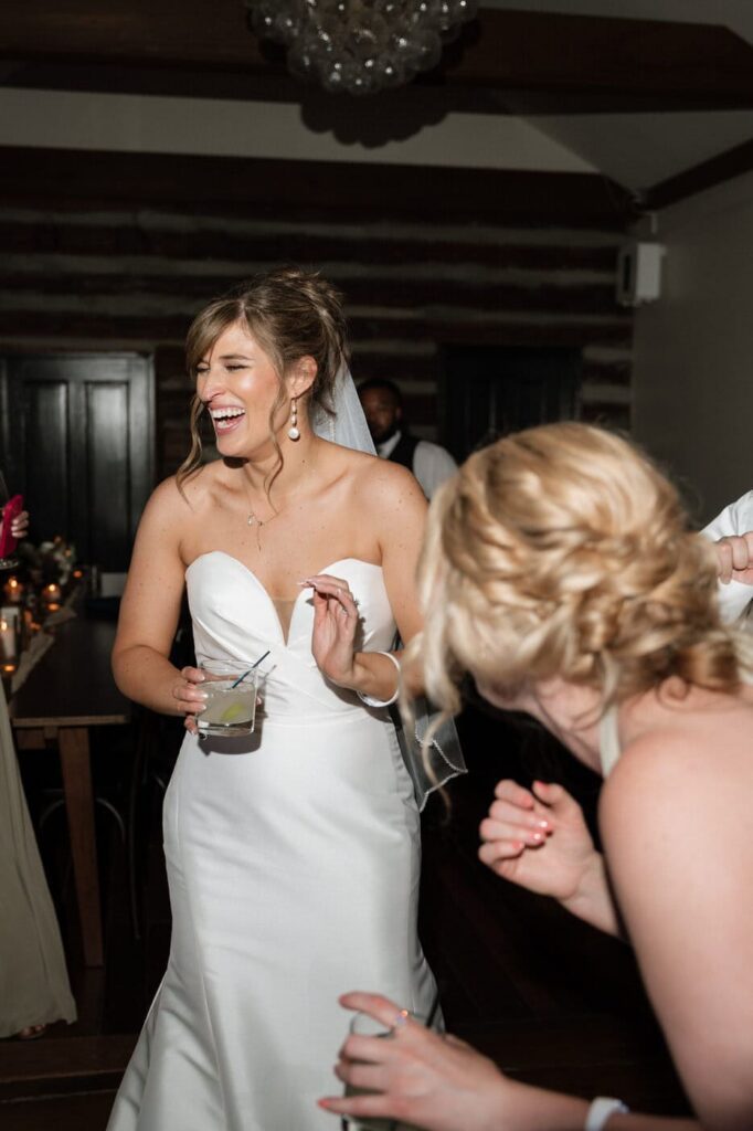 bride laughing with her friends at the wedding reception in east nashville