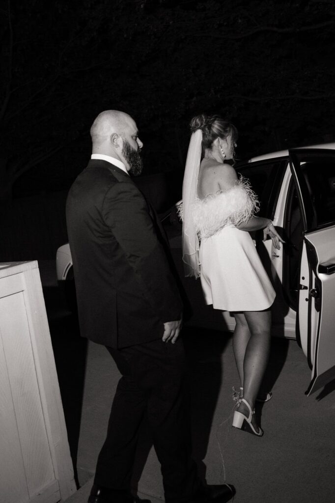 bride and groom getting into rolls royce getaway car