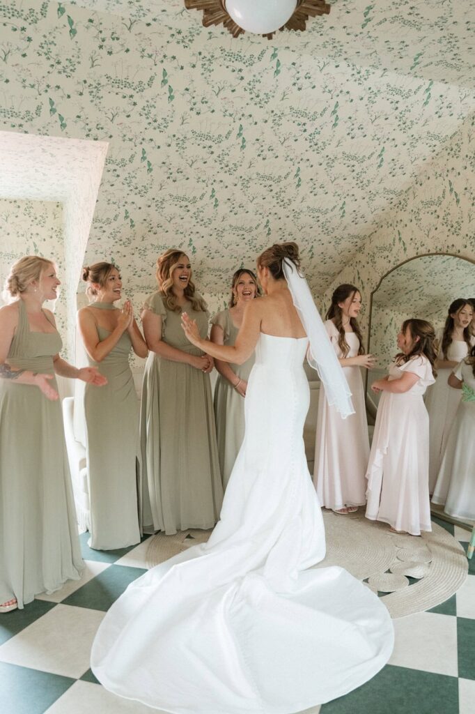 bride doing a first look with her bridesmaids at the estelle's bridal suite