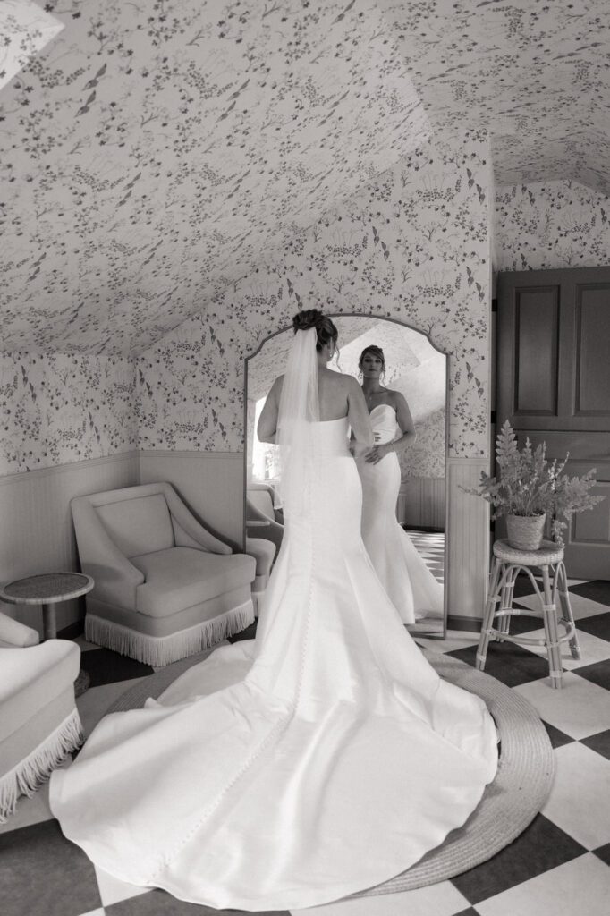 bride looking at herself in the mirror before her first look